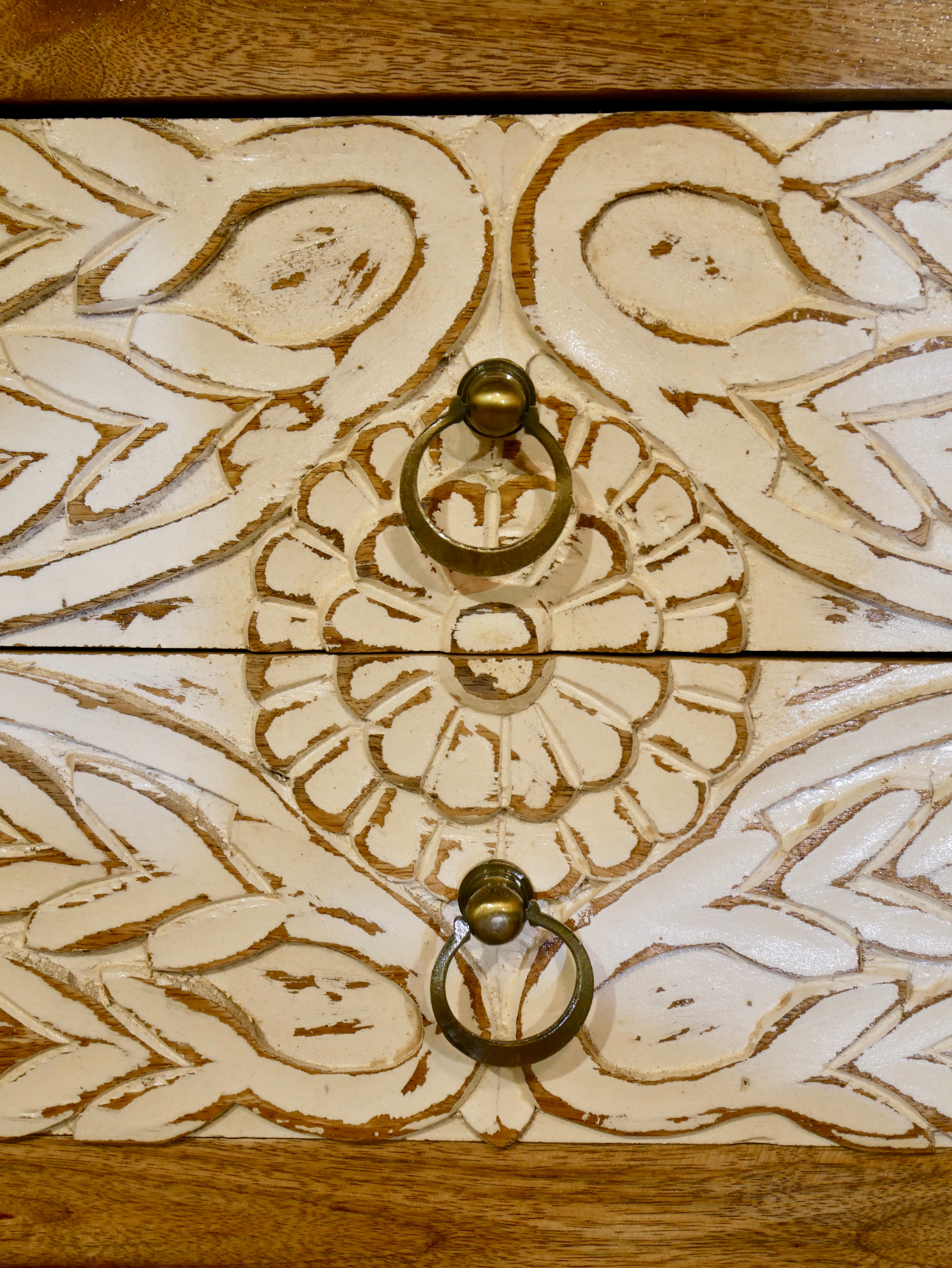 Close up image of a white washed mango wood console table with floral hand-carved drawers and lower shoe shelf; rustic mango wood furniture, 90 × 40 × 75 cm.