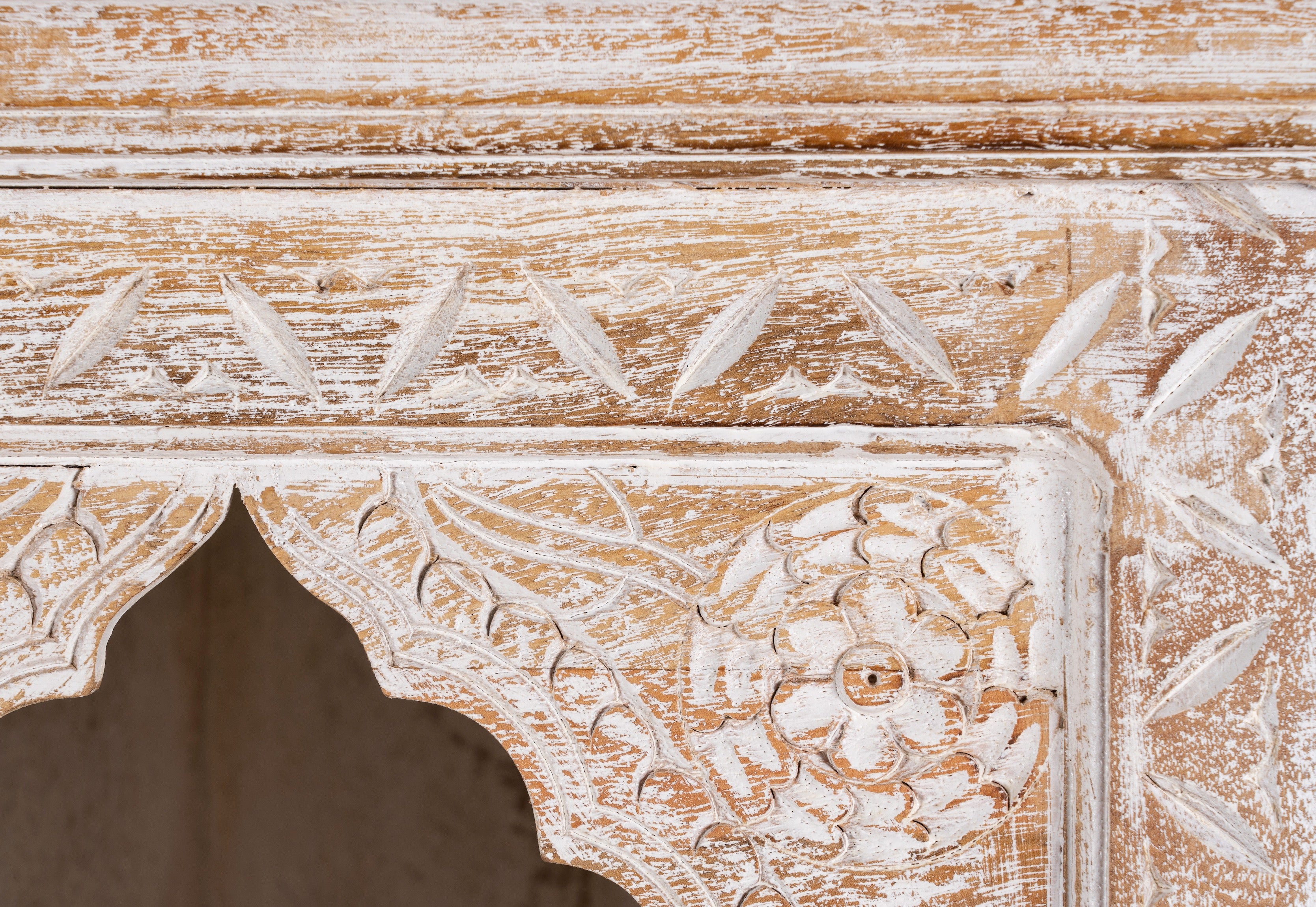 Close up image of a hand-carved mango wood shelving unit with Moroccan arches and whitewashed finish; perfect as an entryway shelf or display piece, 180 × 90 × 40 cm.