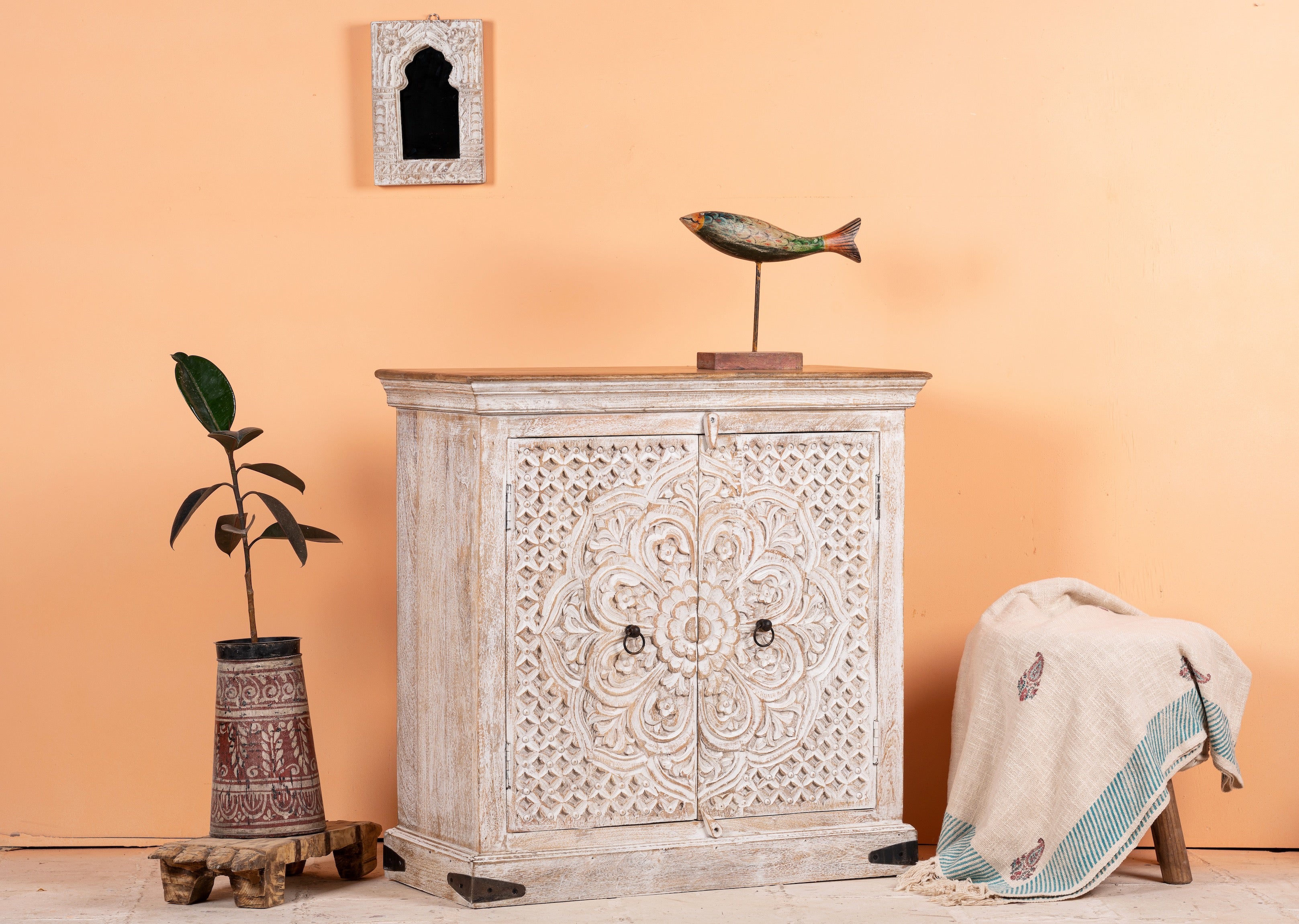 Side angle image of a whitewashed mango wood sideboard with hand-carved floral patterns; compact carved sideboard for vintage interiors, 90 × 90 × 40 cm.