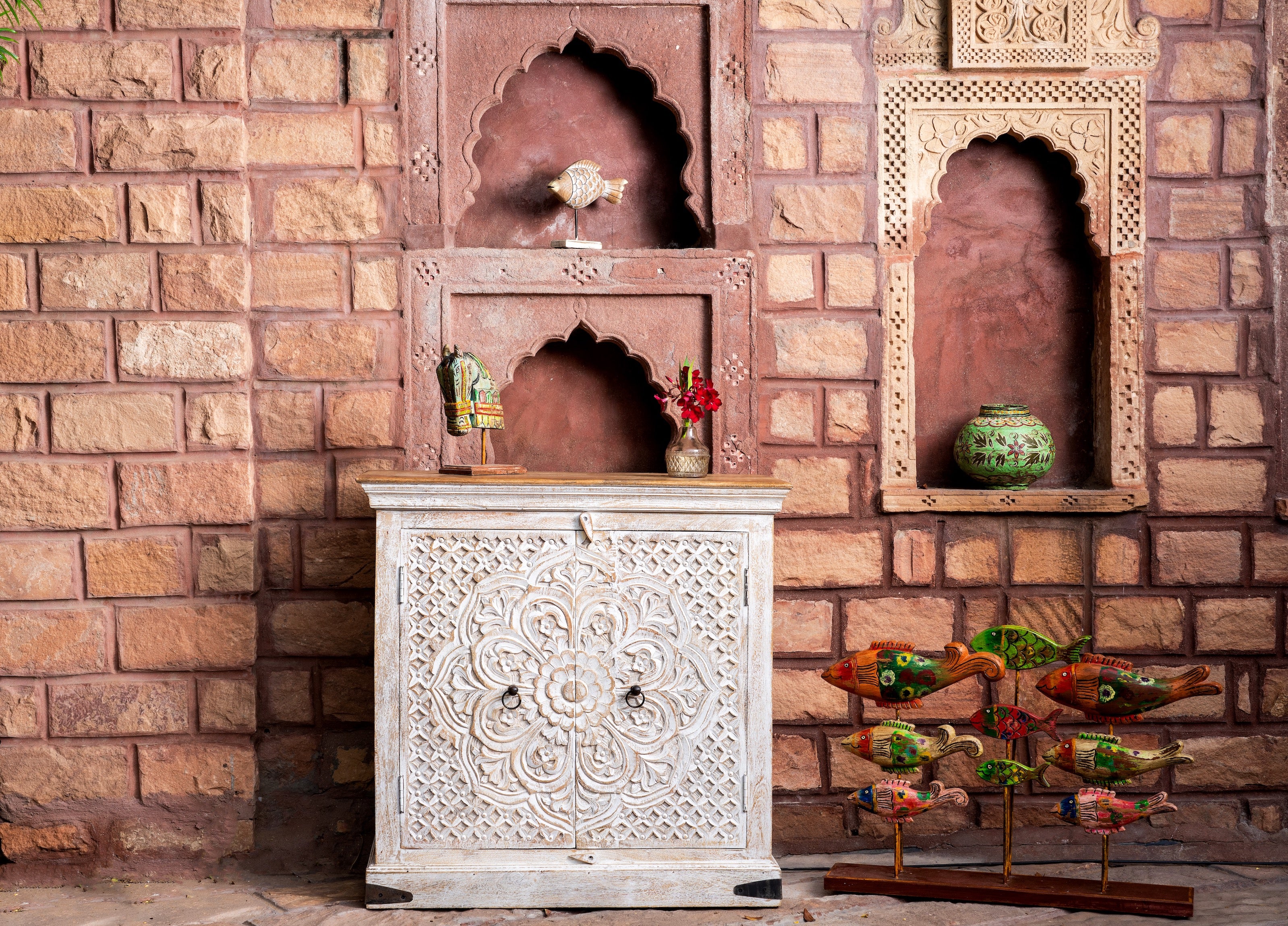 Lifestyle image of a whitewashed mango wood sideboard with hand-carved floral patterns; compact carved sideboard for vintage interiors, 90 × 90 × 40 cm.