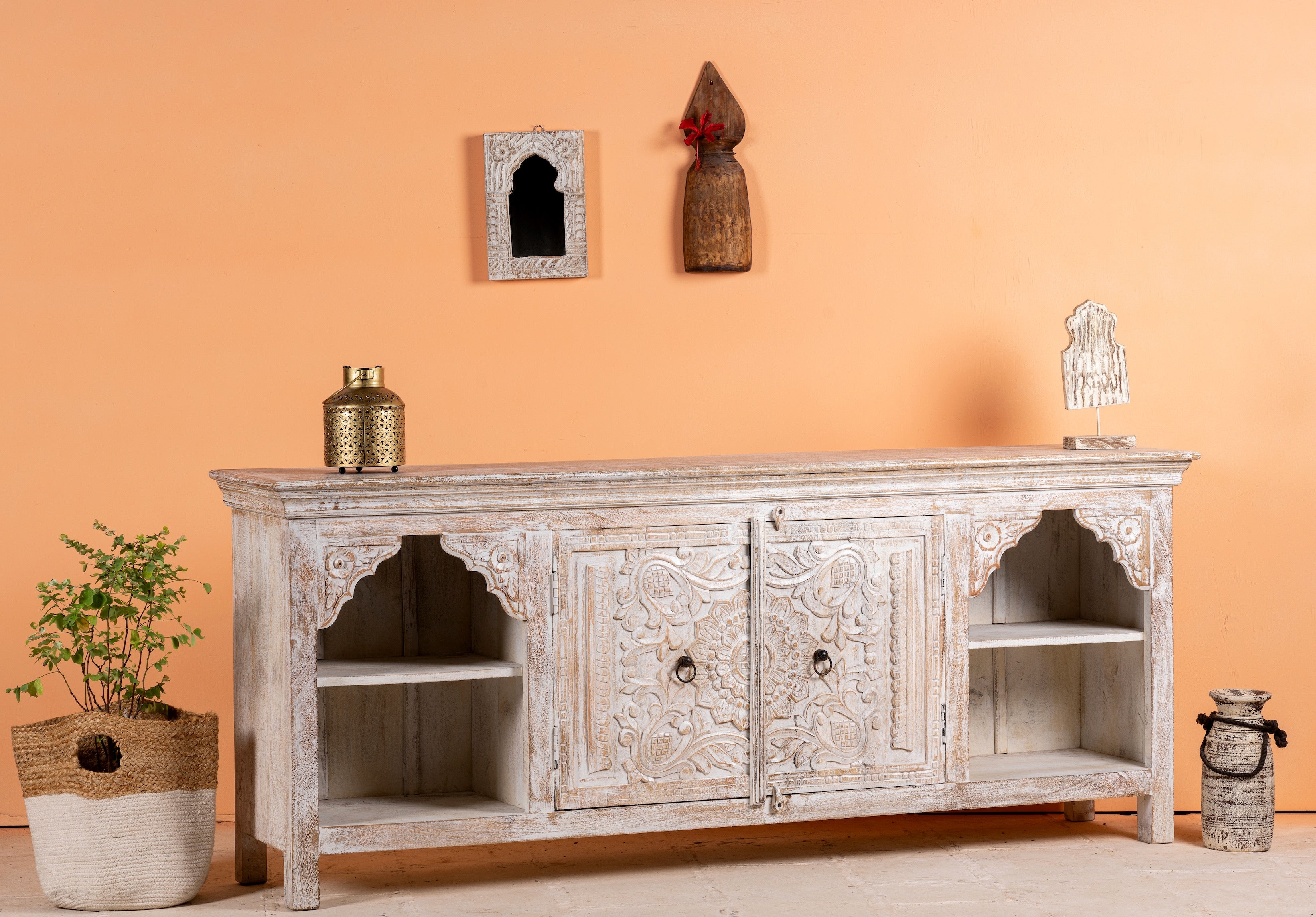 Side angle image of a hand-carved mango wood Mediterranean lowboard with floral engravings and whitewashed finish – carved wooden furniture combining traditional Indian craftsmanship with rustic elegance.