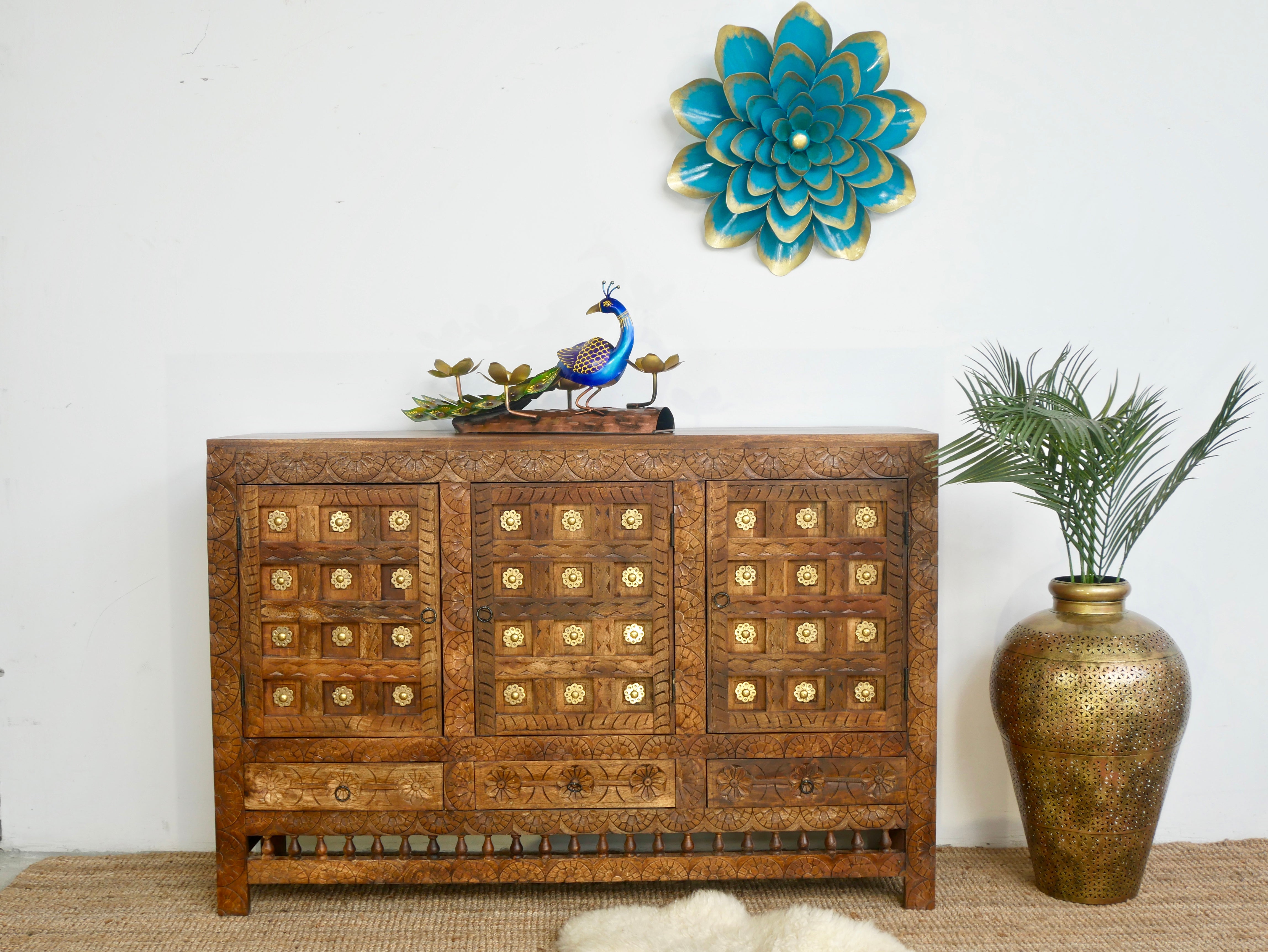 Lifestyle image of a handcrafted traditional sideboard made from mango wood with Indian carvings and brass inlay; Indian furniture, 150 × 100 × 40 cm.