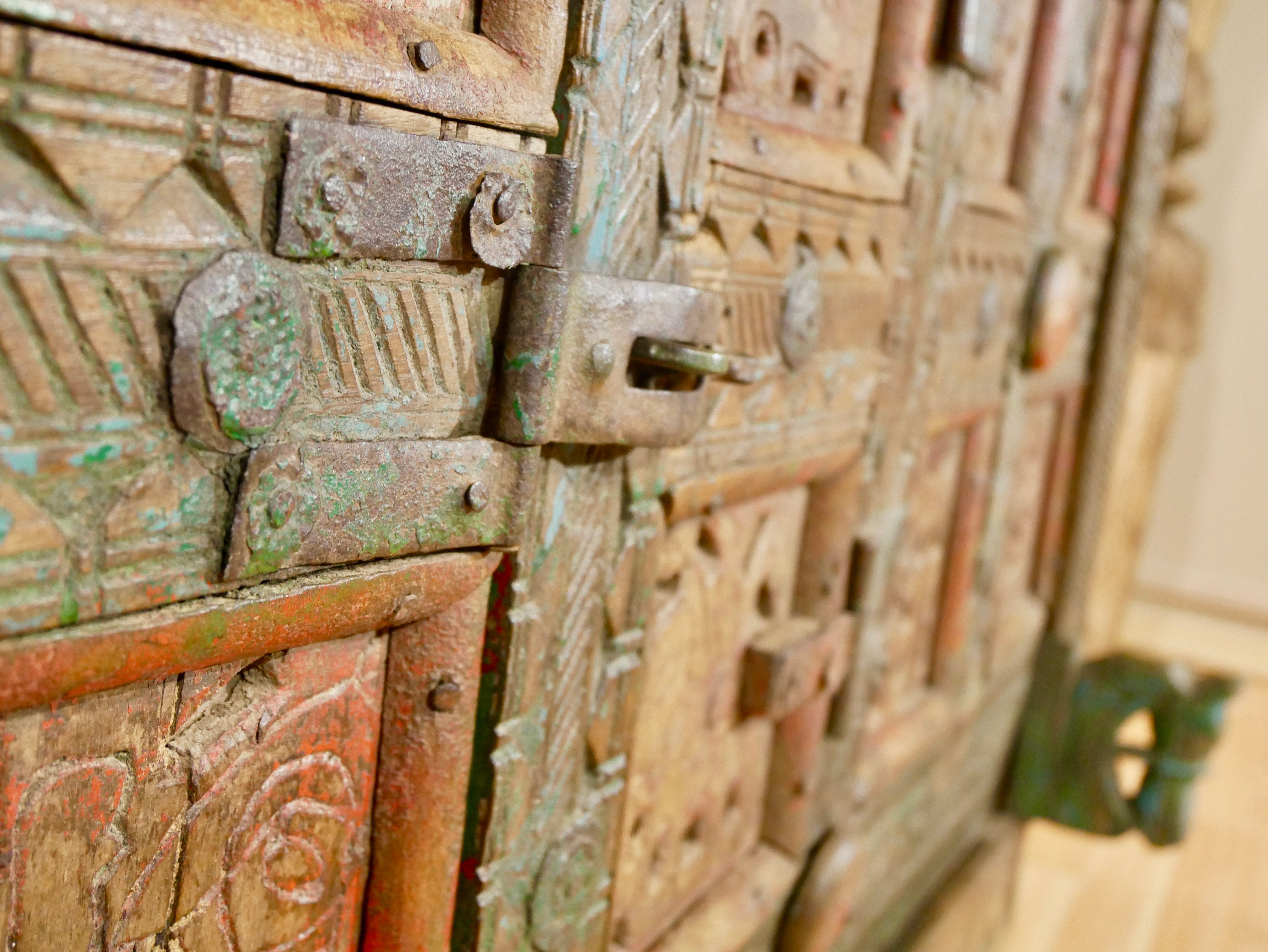 Close up image of the lock of a classic Indian furniture Damchya chest, reclaimed teak wood with hand-carved details and iron fittings; perfect for bohemian interior décor, 130 × 66 × 110 cm.