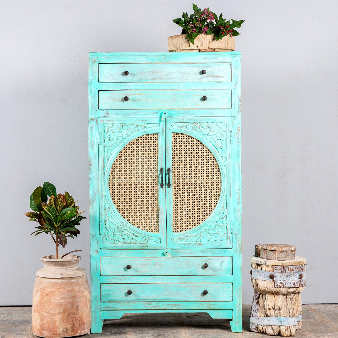 Ganga turquoise vintage cabinetVintage furniture cabinet in turquoise-washed mango wood with rattan door panels and hand-carved engravings, 80 × 148 × 40 cm.