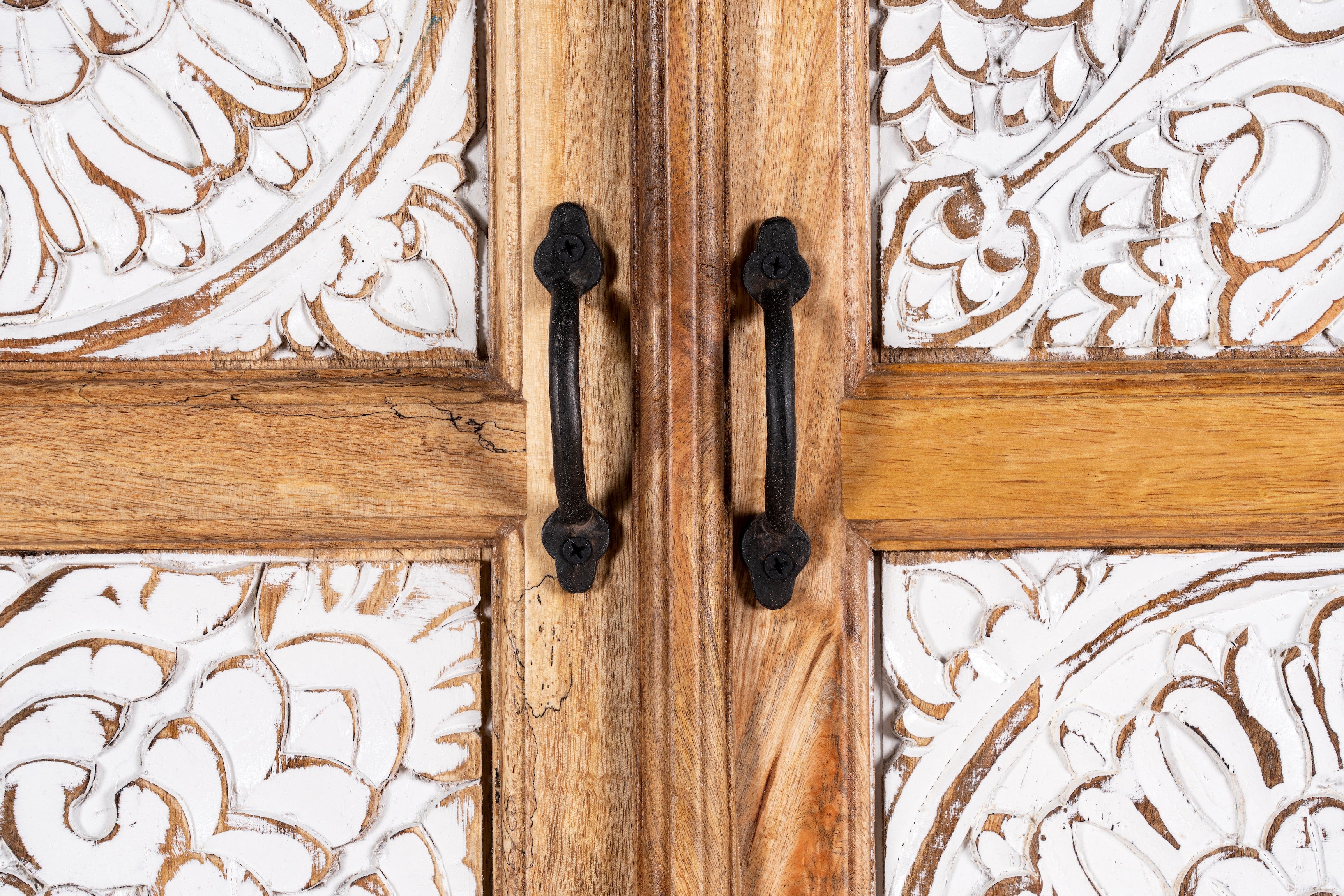 Close up image of a hand-carved wooden wardrobe made from mango wood with whitewashed floral carvings; perfect as bedroom furniture, 90 × 180 × 40 cm.