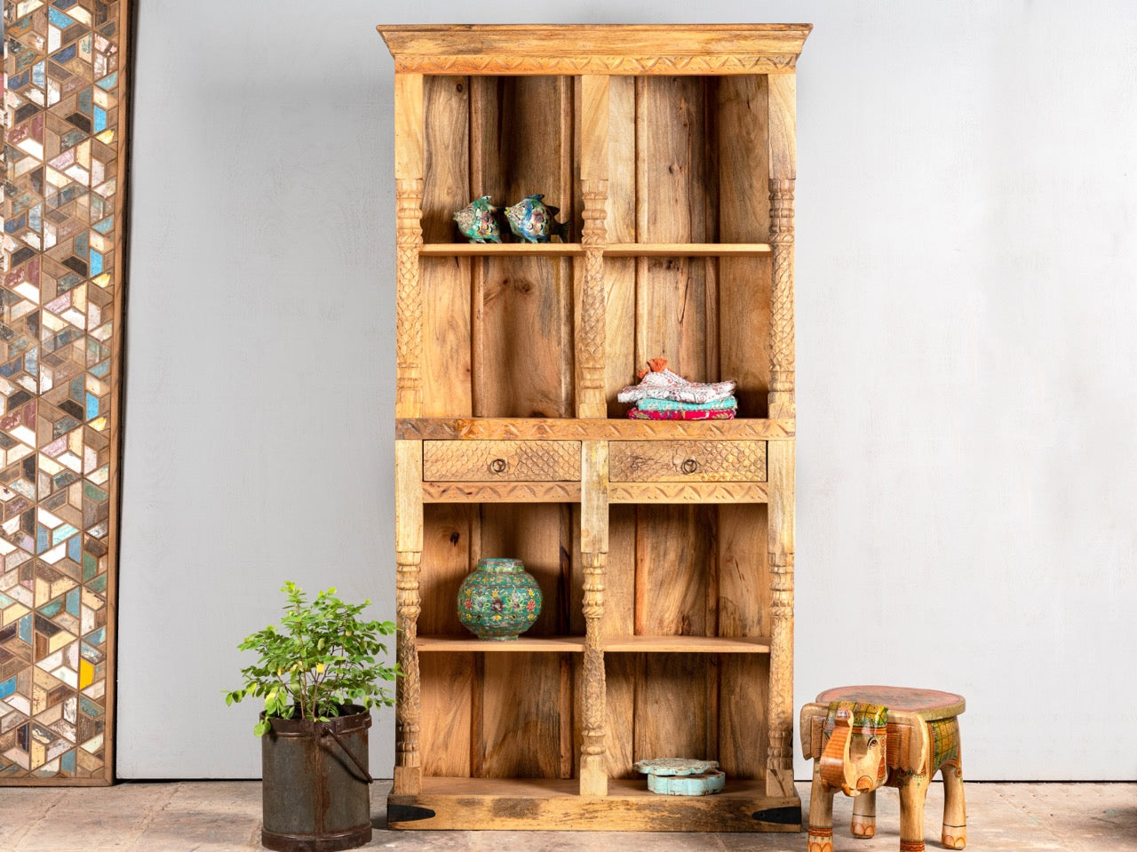 Handcrafted mango wood bookshelf with carved detailing – mango wood shelving and carved wooden furniture in a warm brown finish for timeless interiors.