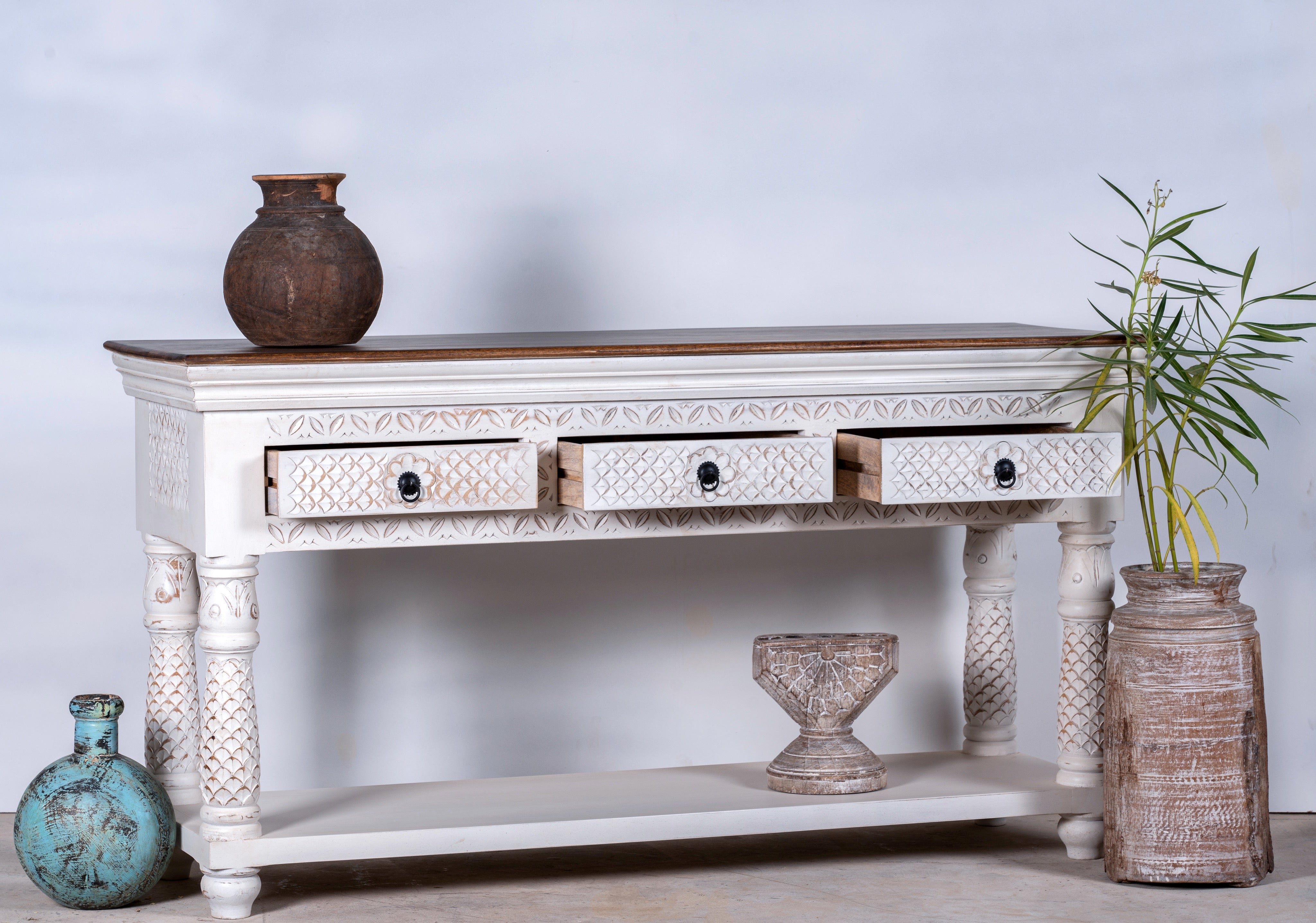 Image with open drawers of a carved mango wood console table with floral ornamentation; rich, exotic mango wood furniture, 150 × 90 × 45 cm.
