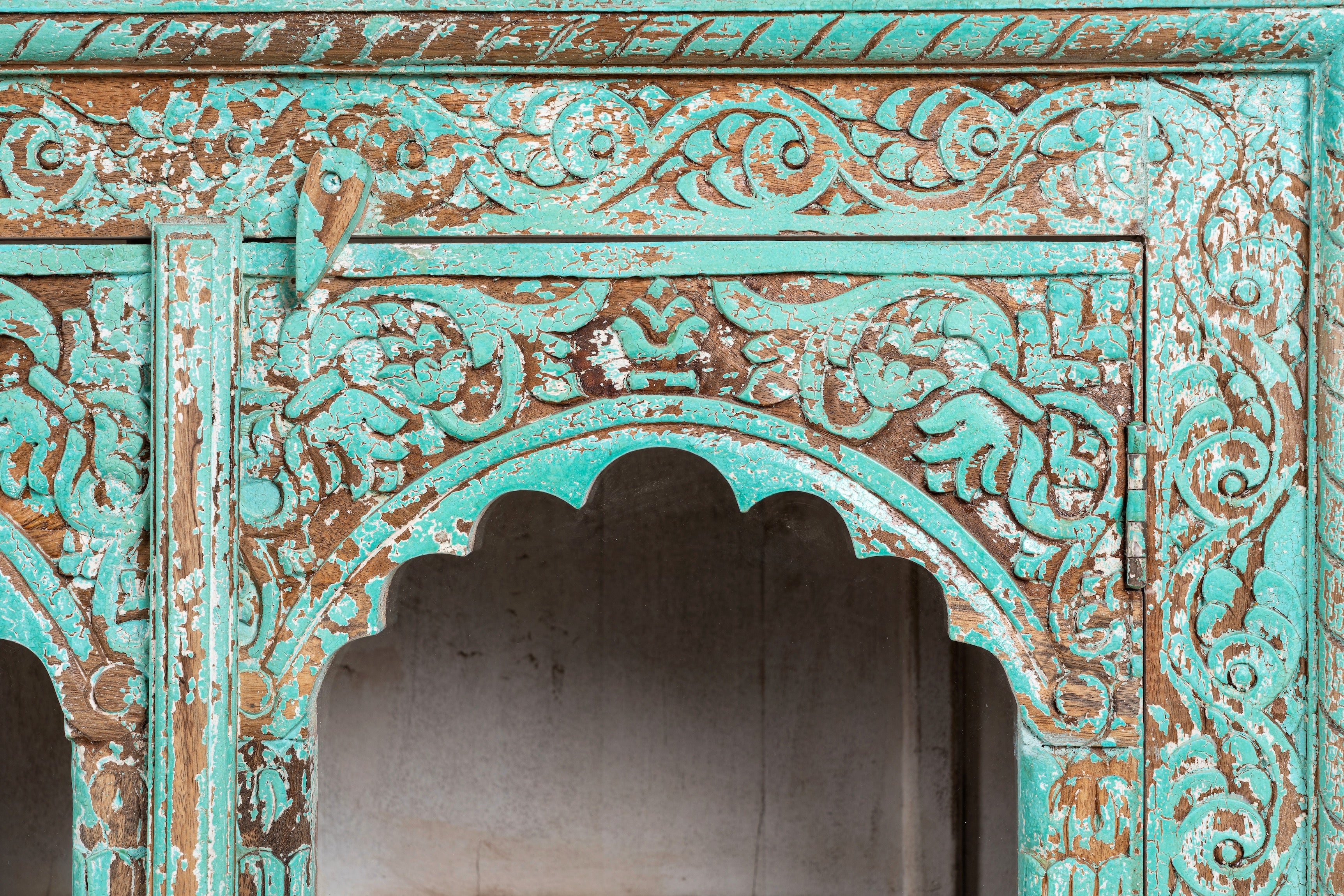 Close up image of Jesar wood carved sideboard in turquoise finish, a vibrant statement for a boho chic living room.