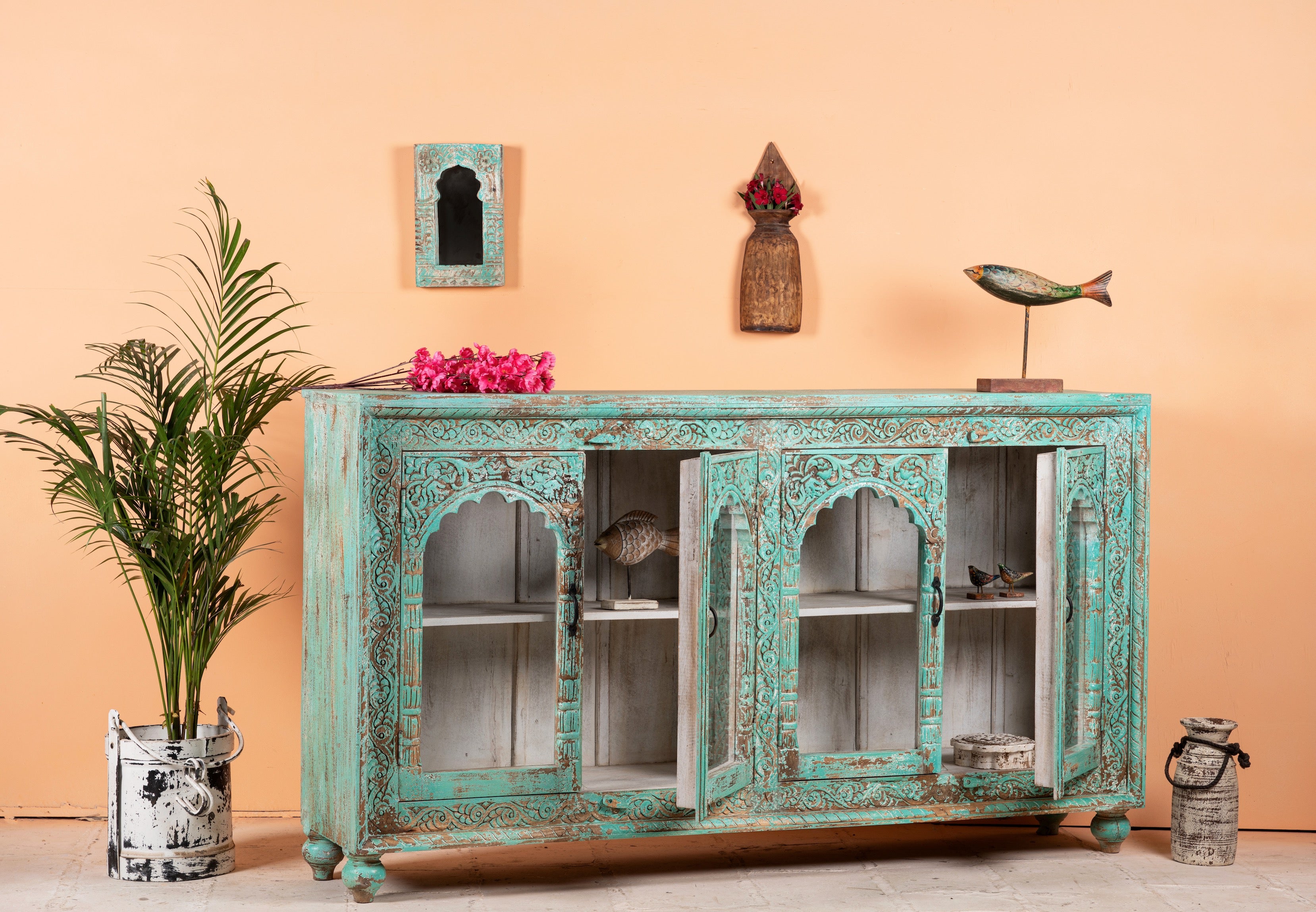 Open door image of Jesar wood carved sideboard in turquoise finish, a vibrant statement for a boho chic living room.
