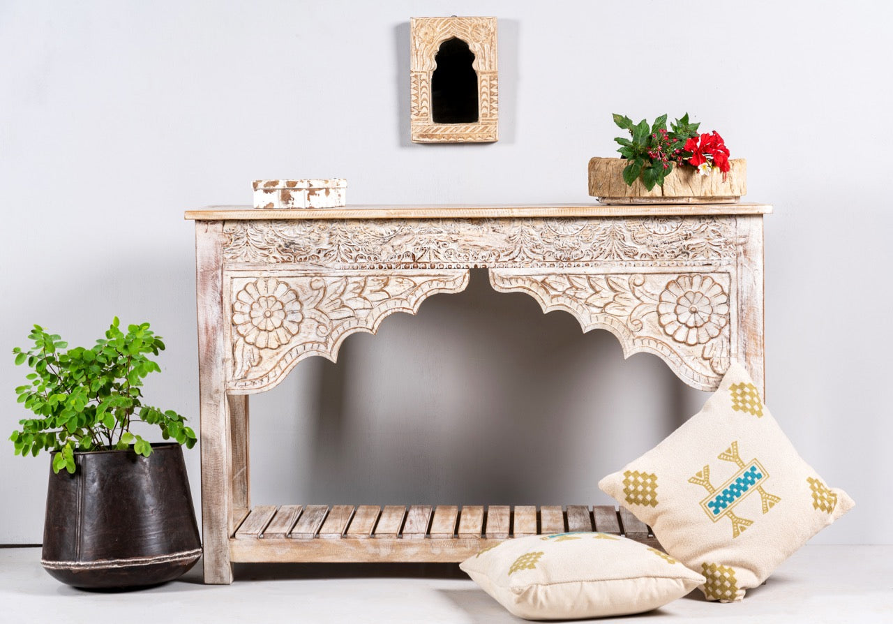Lifestyle image of a Kolkata carved wood console table in solid mango wood, vintage entryway table with floral motifs and storage shelf, 130 × 84 × 44 cm.