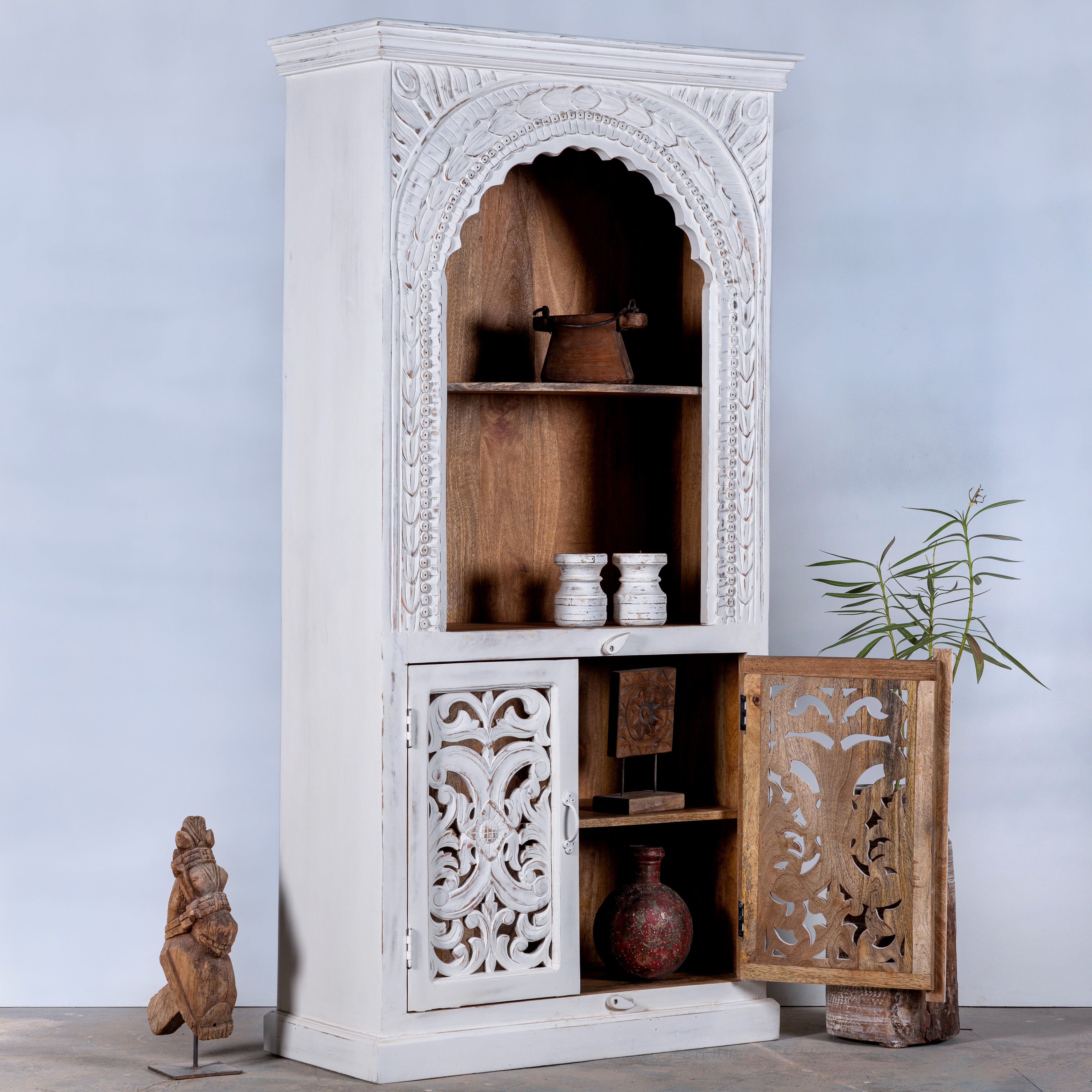 Open door image of a hand-carved mango wood shelving unit with white washed finish and storage compartments – white washed wooden furniture ideal for vintage home accessories and Indian decor style.