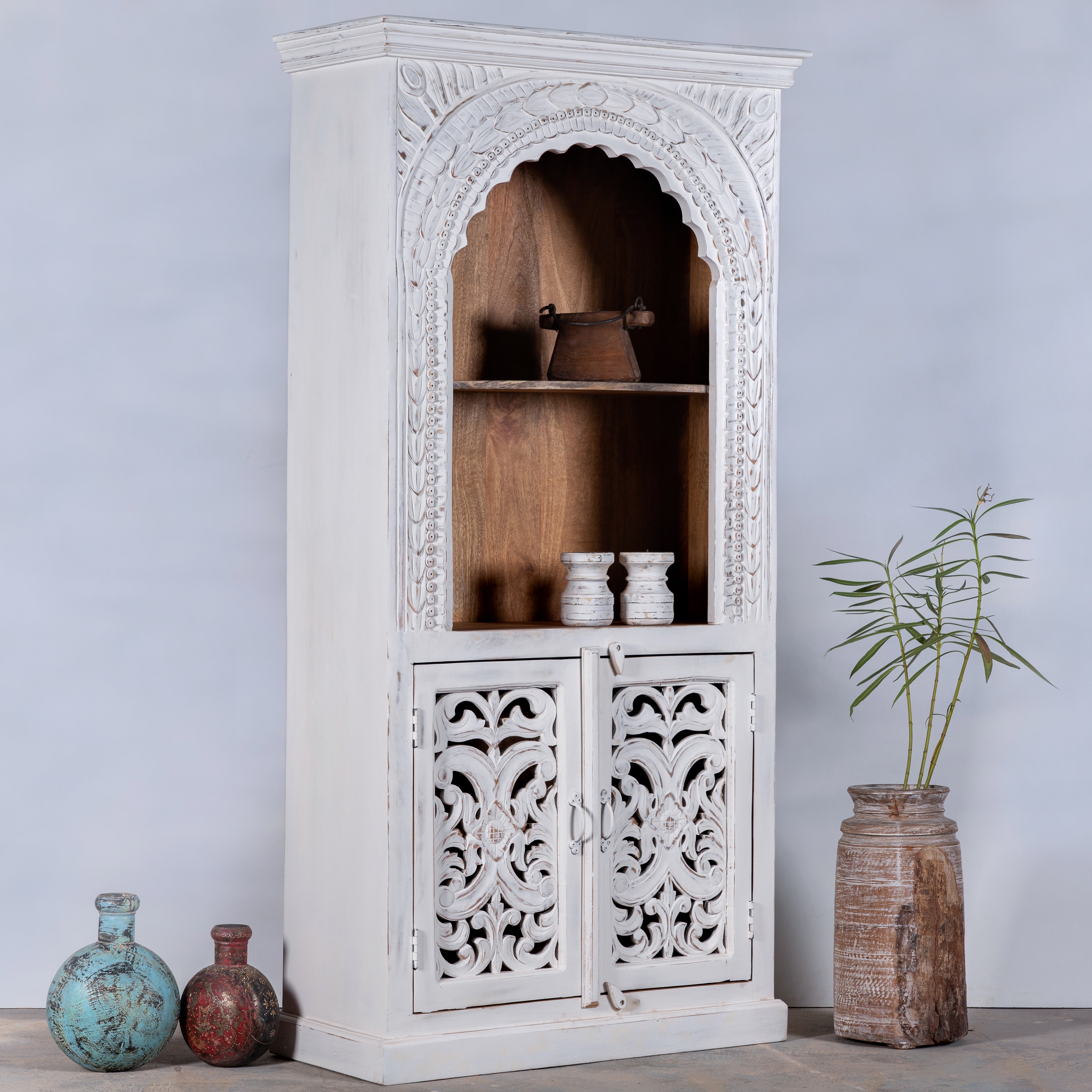 Side angle image of a hand-carved mango wood shelving unit with white washed finish and storage compartments – white washed wooden furniture ideal for vintage home accessories and Indian decor style.