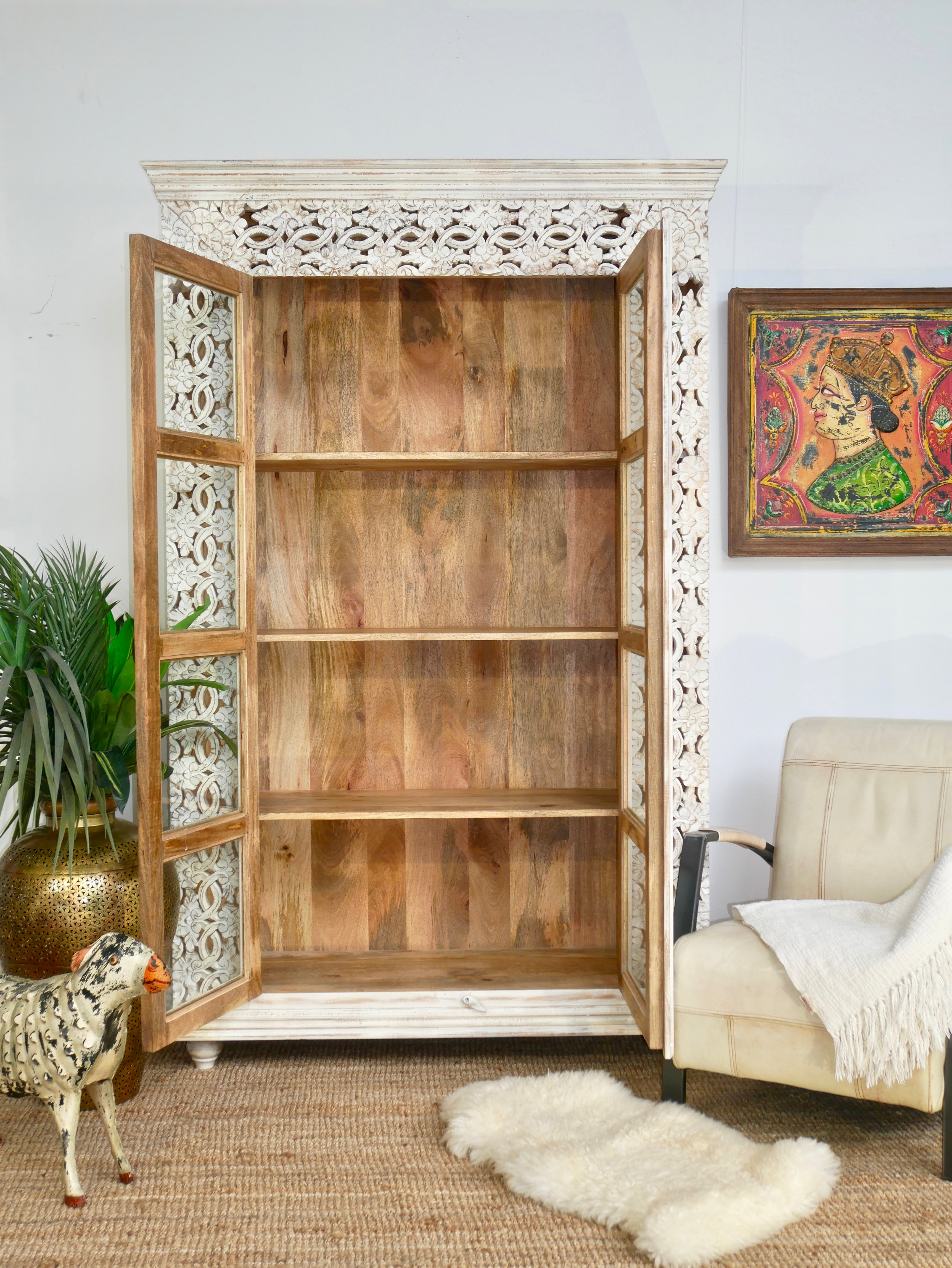 Open door image of a Handcrafted mango wood cabinet with glass-panelled doors and internal storage – carved wood furniture made from sustainable mango wood with unique natural grain.