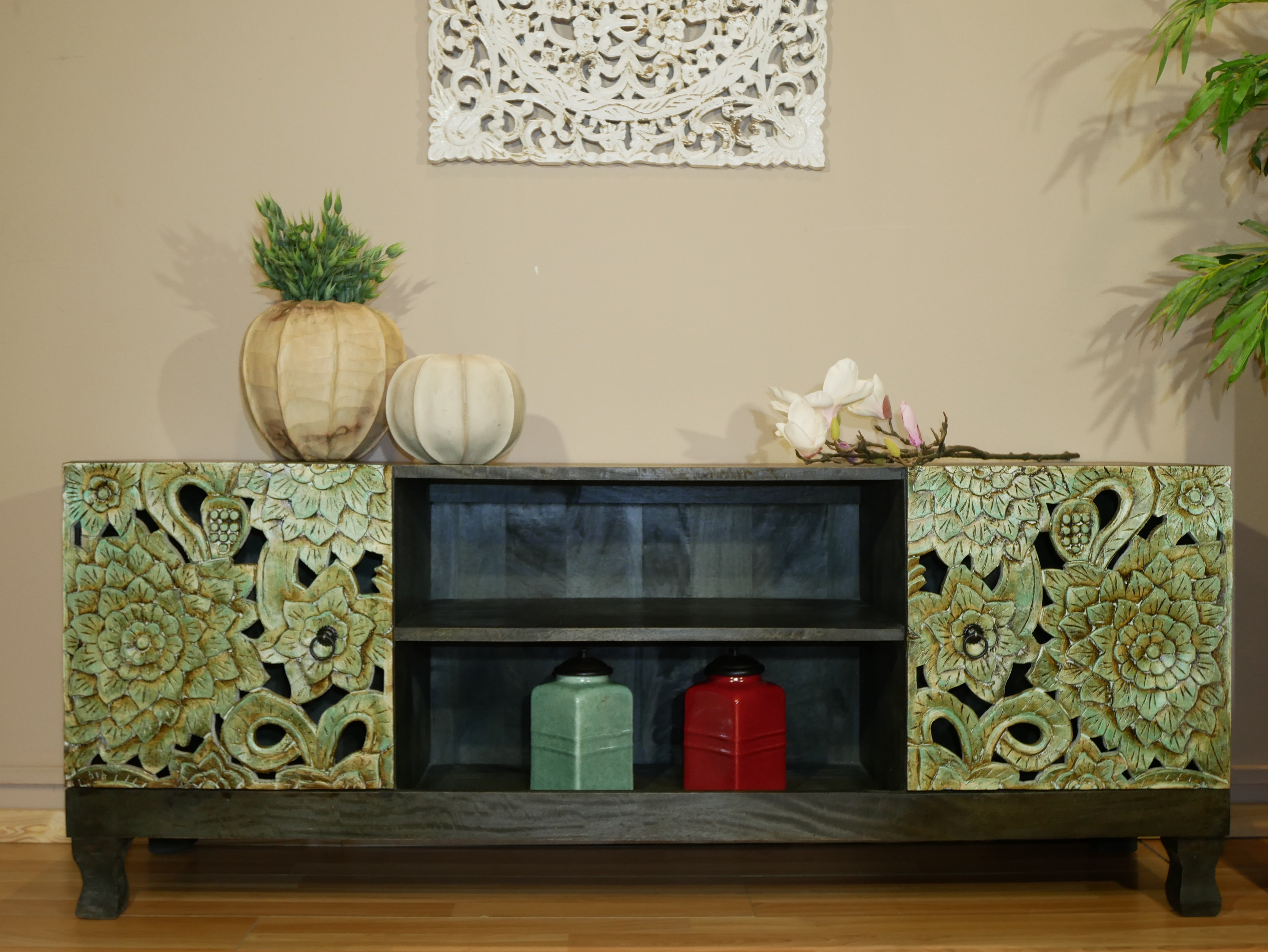 Carved mango wood lowboard with green floral doors, black frame, and open shelving, 150 × 60 × 40 cm.