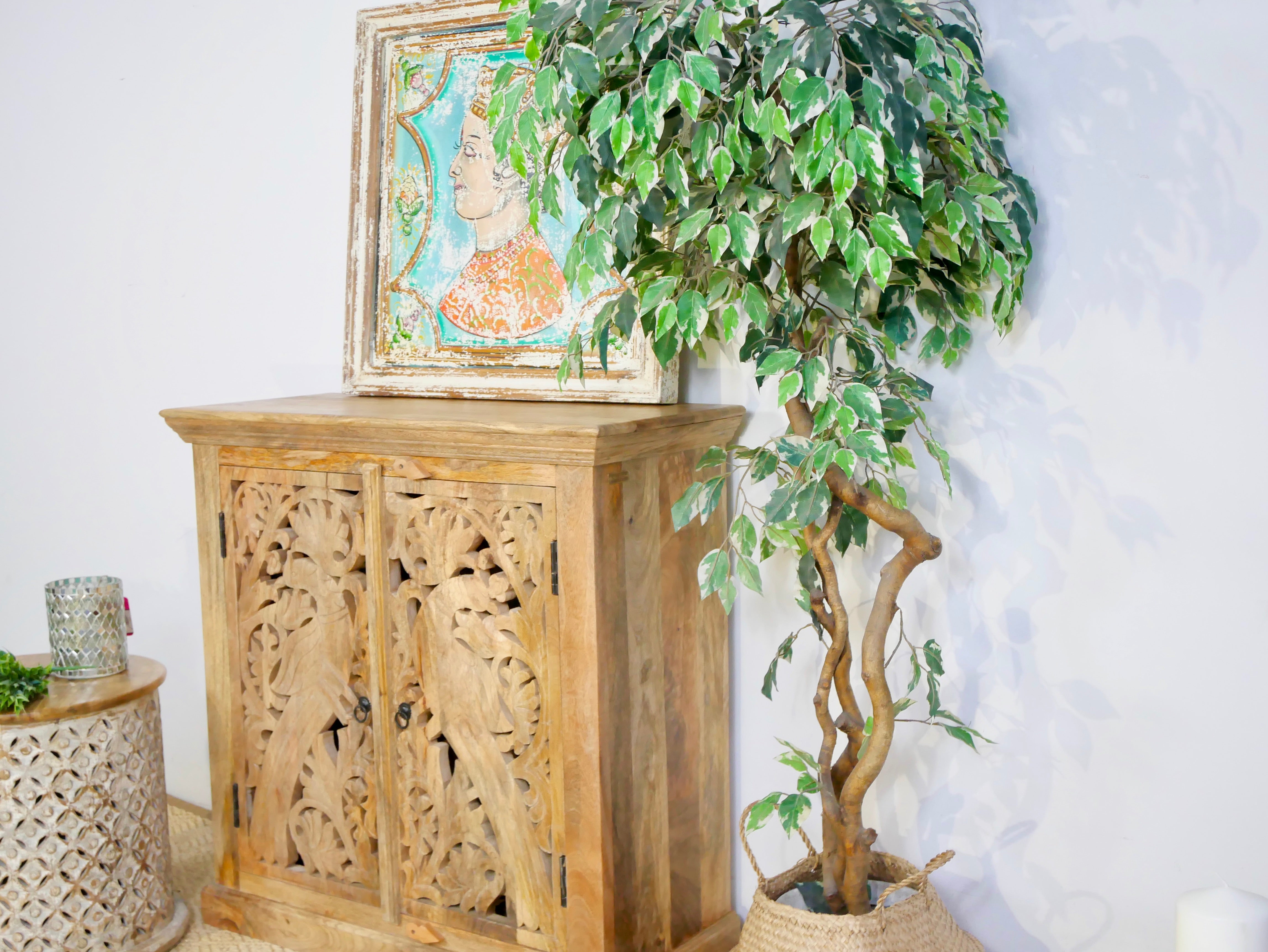 Side angle image of a white washed wooden cabinet with hand-carved peacock doors, handcrafted mango wood furniture, Mediterranean-style storage unit, 90 × 90 × 40 cm.