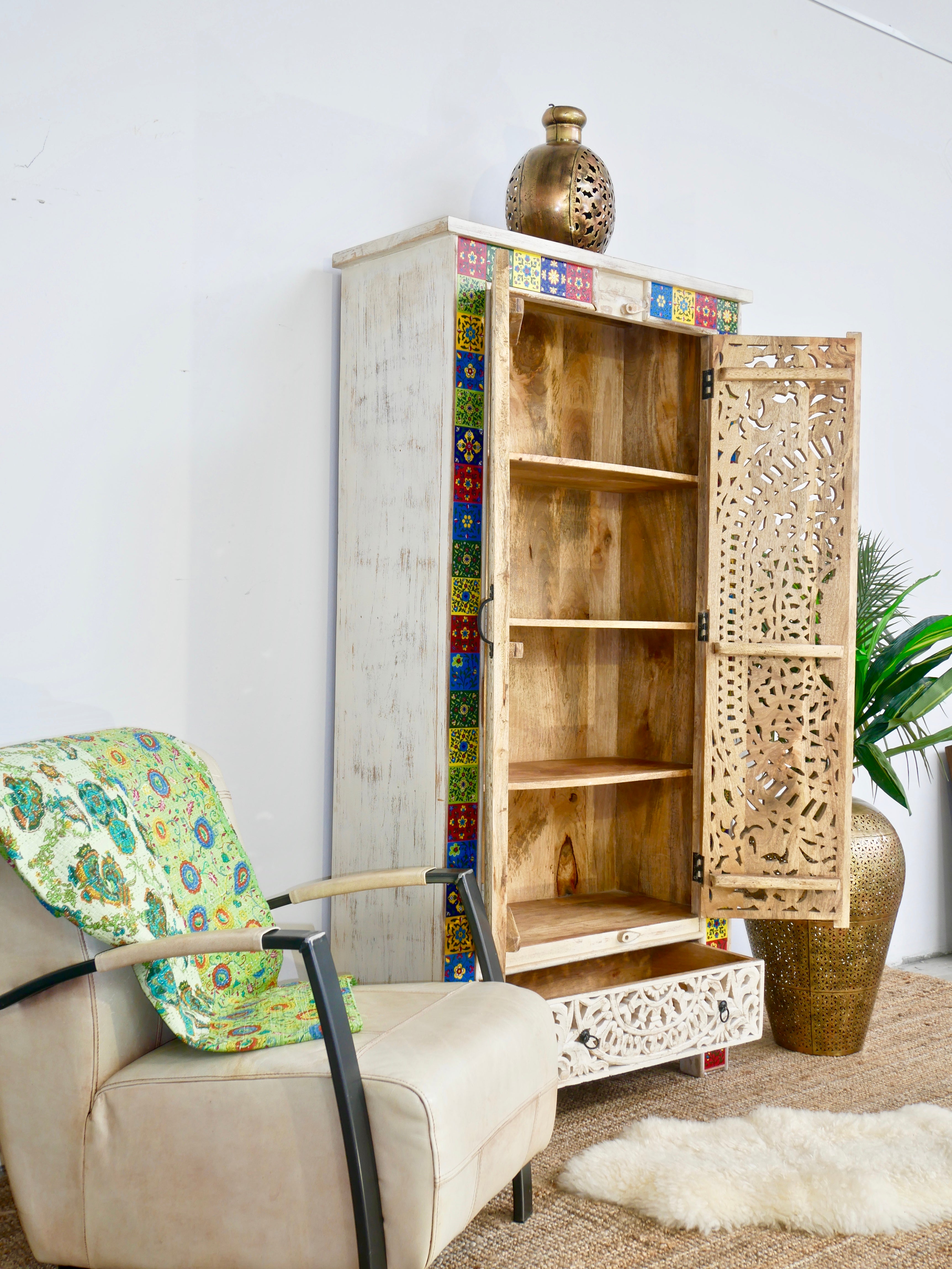 Side angle image with open door of a hand-carved mango wood cabinet with white-wash finish and ceramic detailing – artisanal furniture and carved wooden furniture with Mediterranean flair.