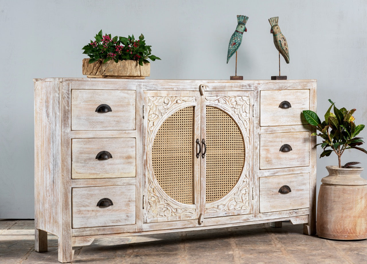 Side angle image of a white mango wood and rattan sideboard with six drawers and two compartments—handcrafted bedroom furniture blending Indian artistry with Scandinavian design.