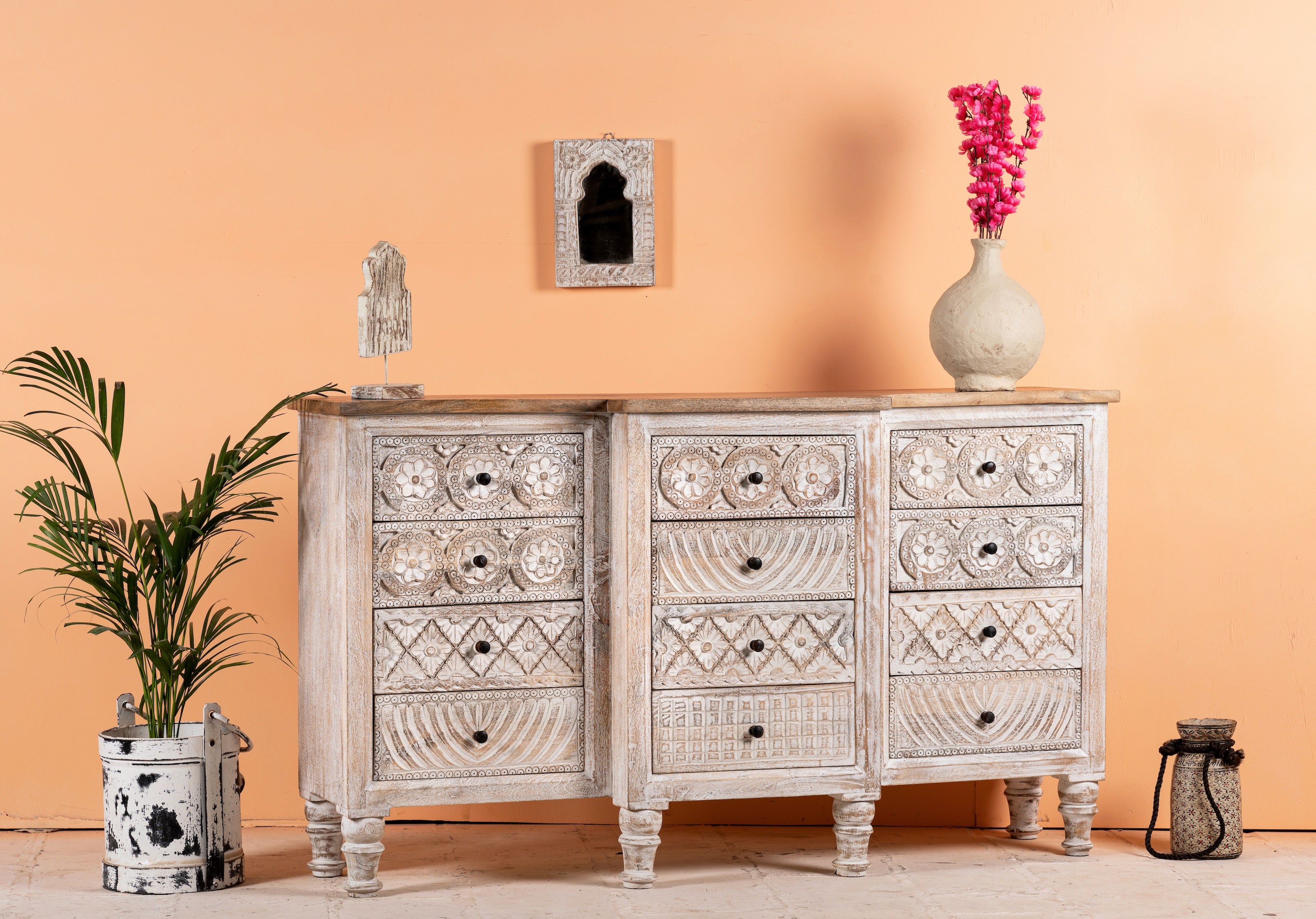 Side angle image of a hand-carved mango wood sideboard with lotus-inspired drawer motifs and whitewashed finish; a wood carved sideboard and unique furniture piece, 160 × 92 × 45 cm.