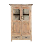 White background image of a reclaimed teak wood showcase Aasta with Mediterranean design, featuring hand-carved doors, glass panels, and drawers. A unique piece of refurbished Indian furniture offering elegant display and practical storage.