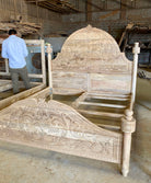 Side angle image of a beautiful hand-carved bed made from solid mango wood. Available in natural or whitewashed finish. Sustainable, artisan-crafted, and full of character.

