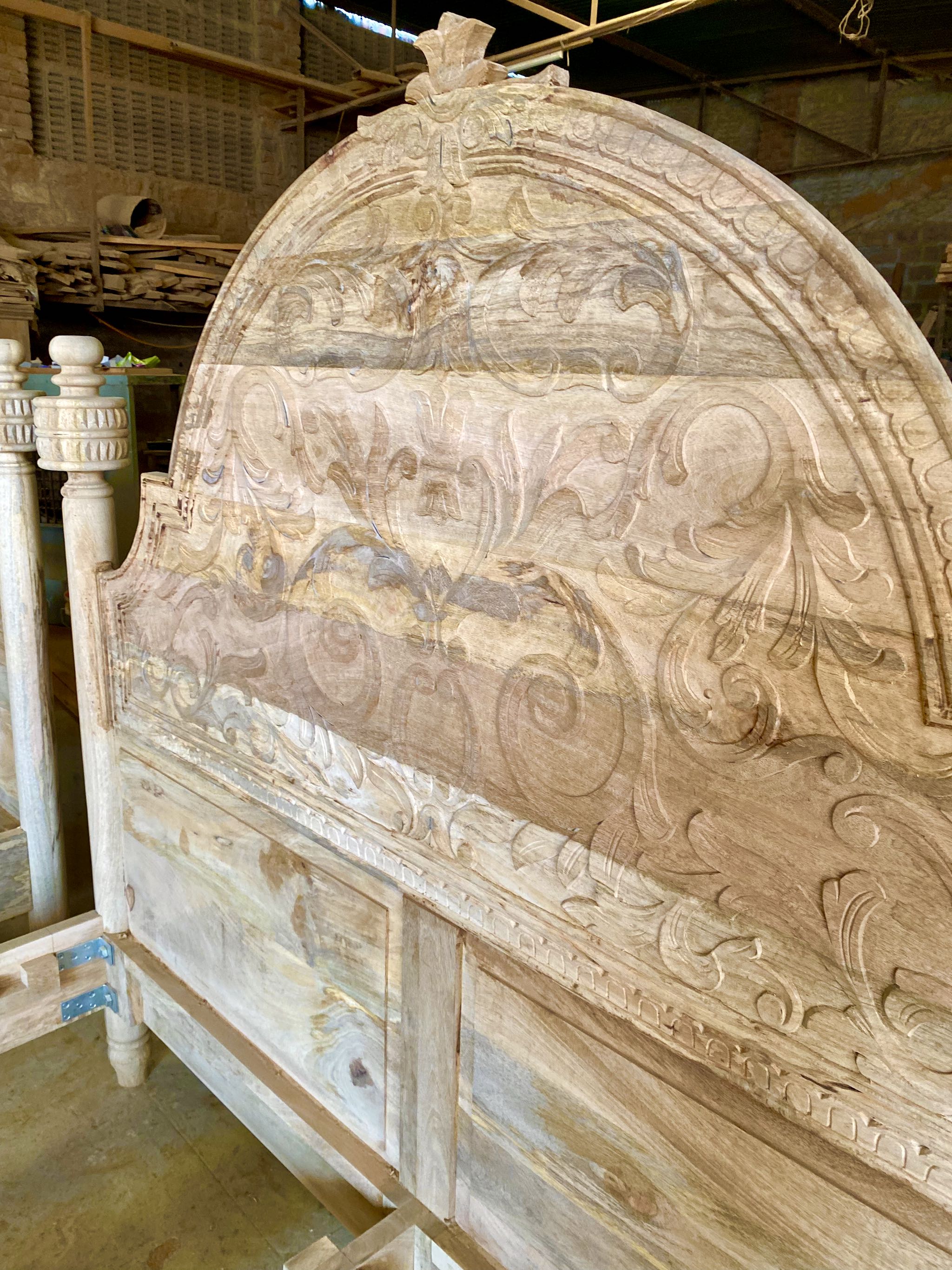 Close up image of a beautiful hand-carved bed made from solid mango wood. Available in natural or whitewashed finish. Sustainable, artisan-crafted, and full of character.

