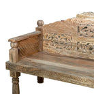 Close up image of a hand carved mango wood bench, featuring intricate floral detailing and turned legs, representing traditional Indian craftsmanship and authentic hand carved wooden furniture design.