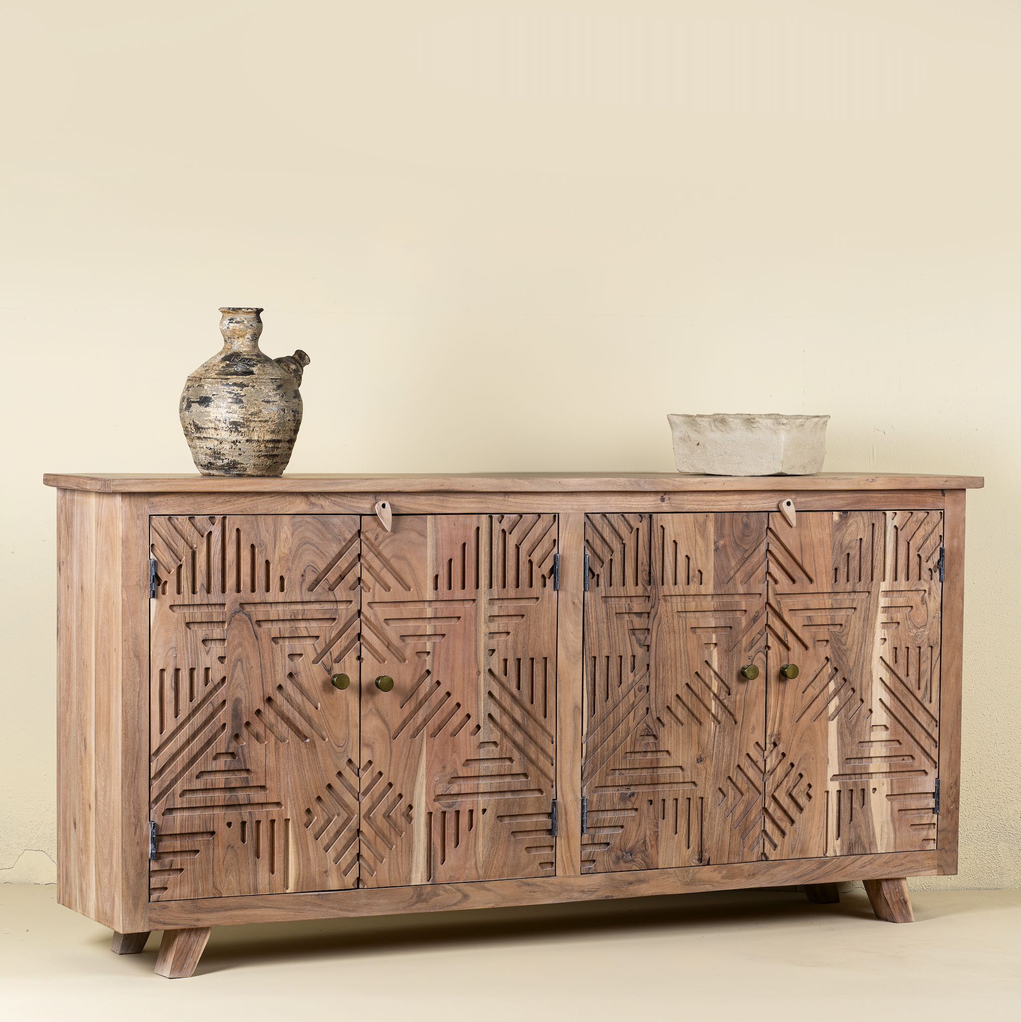 Side view of a sideboard with 4 doors carved with geometrical patterns made of acacia wood.