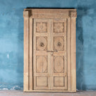 One-of-a-kind antique Indian teak door with sandblasted finish, original brass locks, and reclaimed wood frame extended to European height standards.
