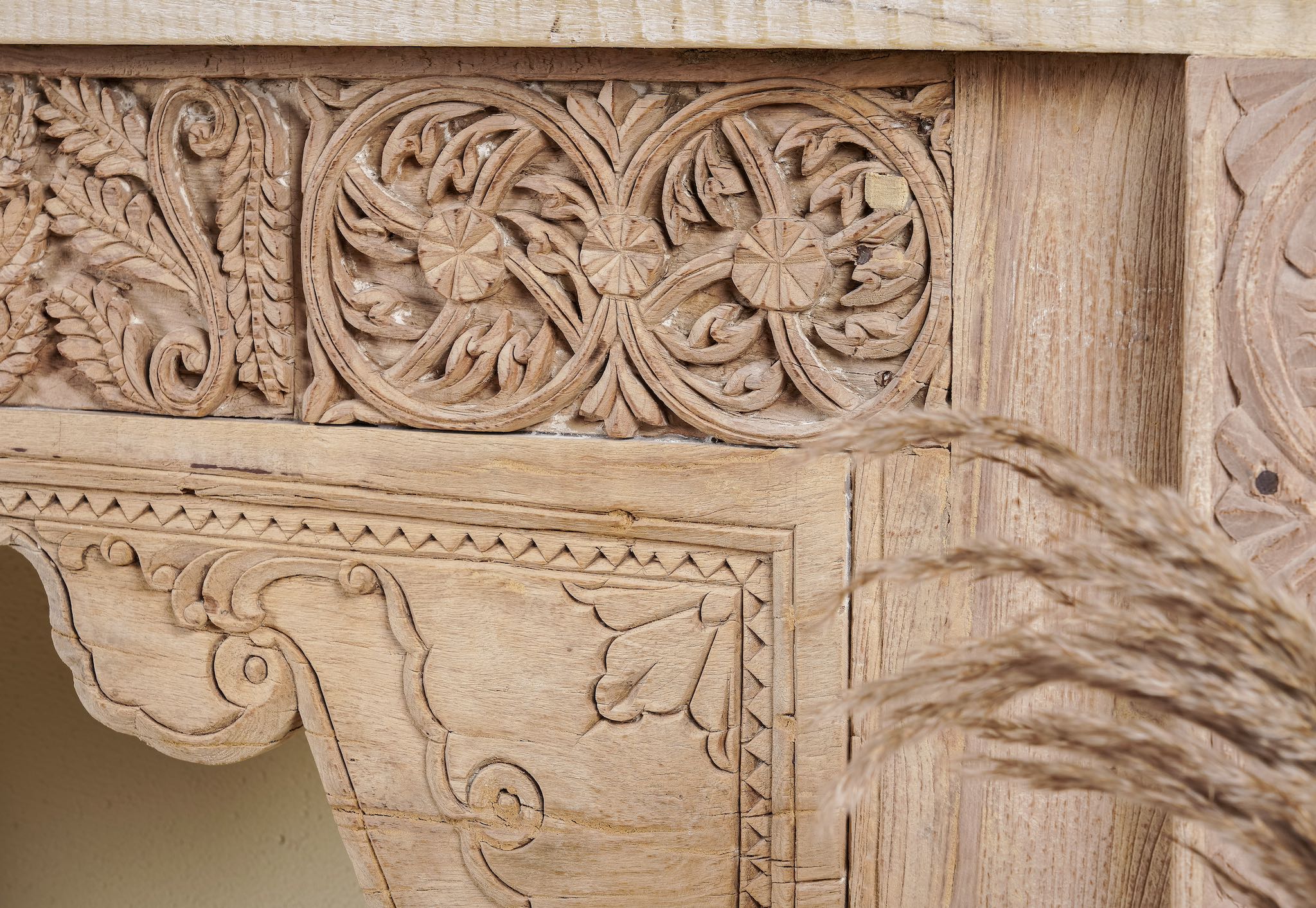 Close up image of a antique teak console table made from reclaimed wood with hand-carved floral and geometric panels, 183 × 40 × 82 cm.