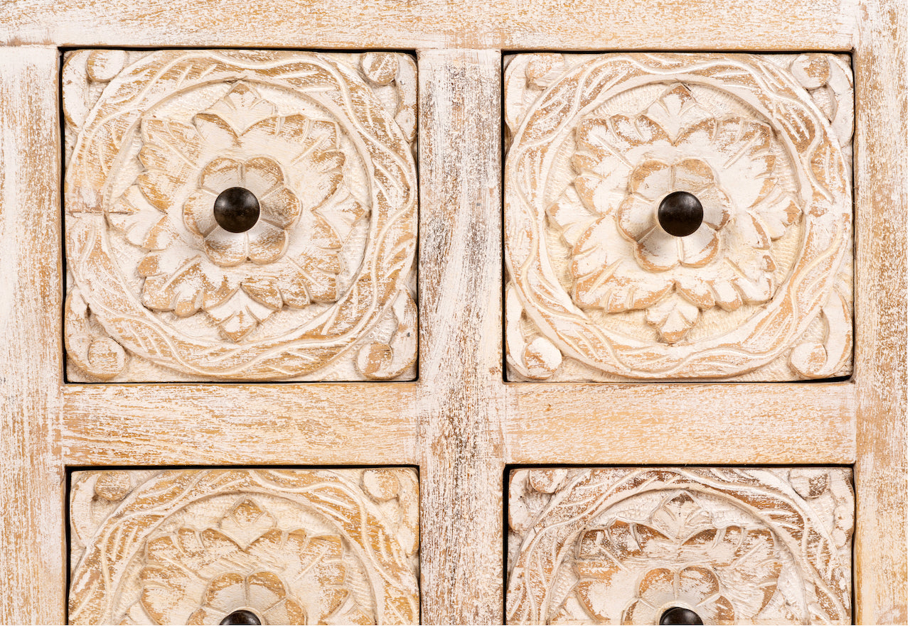 Close up image of a hand carved lowboard in mango wood, a stylish mango wood TV unit with whitewashed floral design.