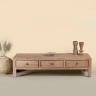 Minimalistic wooden coffee table made from reclaimed wood with three drawers; natural finish, 150 × 60 × 45 cm.