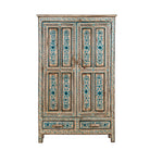 White background image of a tall cabinet made from reclaimed wood, featuring hand-painted floral motifs in soft blue tones on panelled doors and drawers, with a distressed finish that adds vintage charm and highlights its artisanal craftsmanship.
