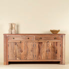 Front view of a modern style handcrafted acacia wood sideboard with 4 doors and 2 drawers with sunburst carvings.