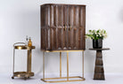 Side angle image of a tall mango wood cabinet with diamond tile carving, bronze handles, and black metal base, 86 × 42 × 150 cm.