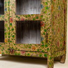 Close up picture  of an and-painted floral showcase cabinet made from reclaimed wood with glass panelled doors and vintage rustic finish.