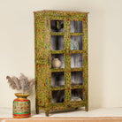 Side angle image of  an hand-painted floral showcase cabinet made from reclaimed wood with glass panelled doors and vintage rustic finish.