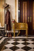 Lifestyle imagination of a hand-painted tiger chair made from recycled teak wood with carved tiger motif; ideal for a boho chic living room, 87 × 75 × 96 cm.