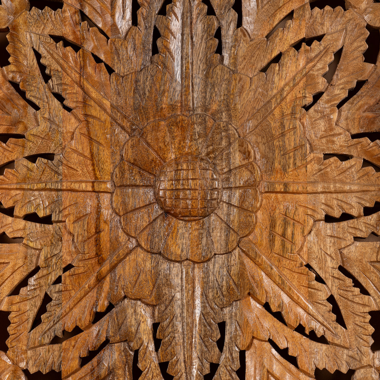 Close up image of a hand-carved mango wood wall panel with floral motifs in natural finish – Arvavasu model by Om Home & Garden