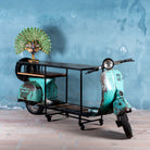 Front image Close of a house bar crafted from a full vintage Indian Bajaj scooter with industrial metal frame and wooden shelves, featuring original patina and retro design elements.

