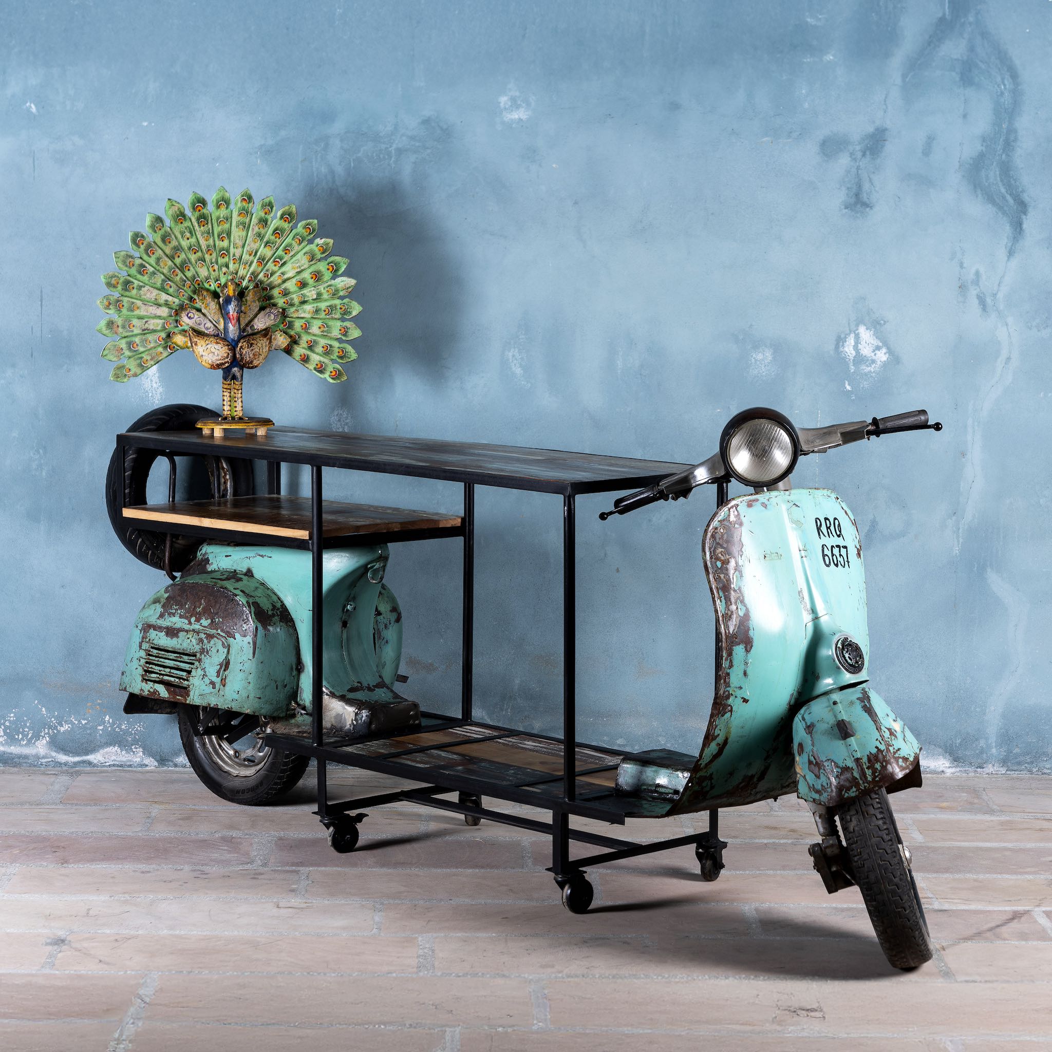 Front image Close of a house bar crafted from a full vintage Indian Bajaj scooter with industrial metal frame and wooden shelves, featuring original patina and retro design elements.


