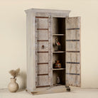 Wooden cabinet with open doors displaying decorative items on a neutral background