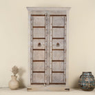 Decorative wooden cabinet with intricate carvings on a plain background