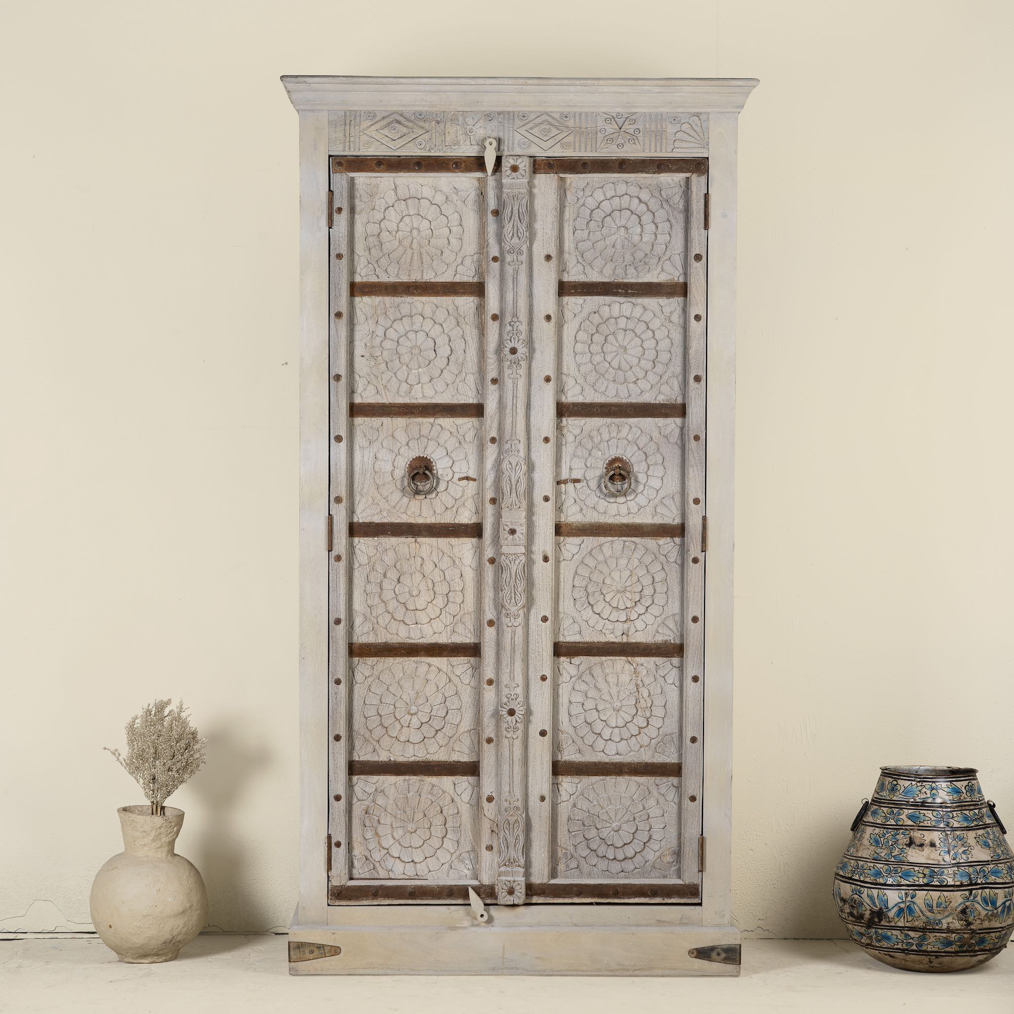 Decorative wooden cabinet with intricate carvings on a plain background