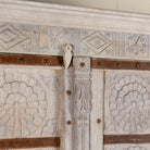 Decorative wooden panel with geometric patterns and a metal strap