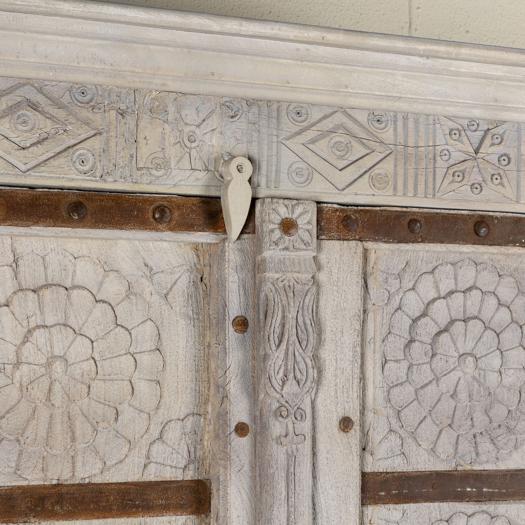 Decorative wooden panel with geometric patterns and a metal strap