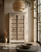 Living room scene of a old teak door wardrobe with floral carvings and original iron fittings.