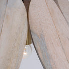 Close up image of a vintage pendant lamp made from white-washed mango wood in a floral design, suspended by a brass-plated hanger – elegant mango wood lighting for bedrooms, living rooms, or dining areas.