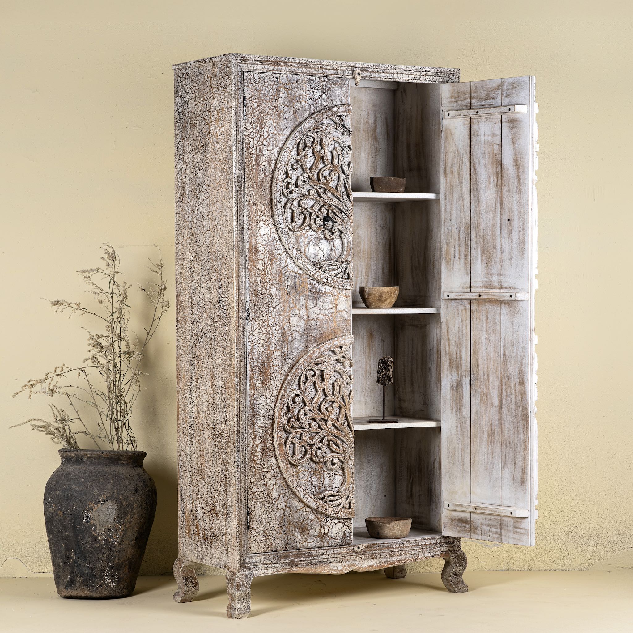 Side angle image with open doors of a vintage style wardrobe with Tree of Life design, hand-carved mango wood furniture with four storage compartments, 90 × 40 × 180 cm.