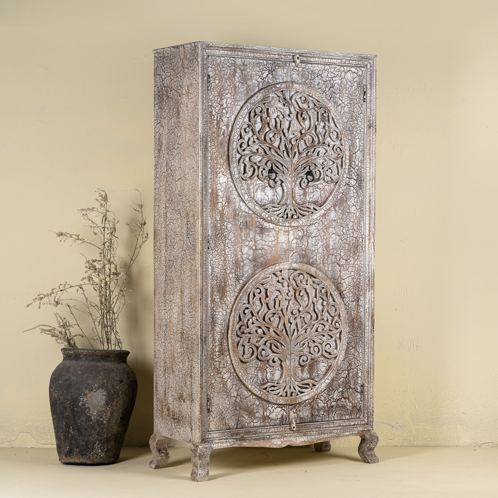 Side angle image of a vintage style wardrobe with Tree of Life design, hand-carved mango wood furniture with four storage compartments, 90 × 40 × 180 cm.