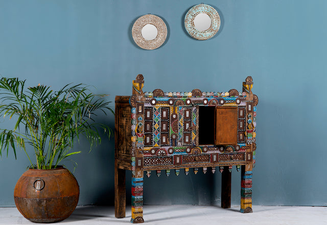 Side angle image with open door of a restored antique Indian Damchia chest crafted from teak wood with original paint, metal fittings, and mirror inlays—an authentic piece of unique Indian furniture for traditional or bohemian interiors.